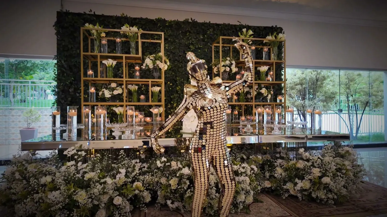 Mesa do bolo com painel de flores e folhagens